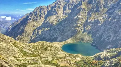 a mountain with a blue lake in front of it at Casa Petra SALGA in Corte