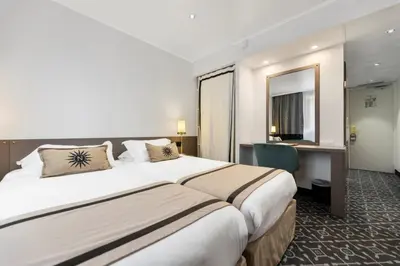 a hotel room with a large bed and a desk at Napoleon in Ajaccio