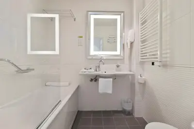 a white bathroom with a sink and a tub and a toilet at Napoleon in Ajaccio