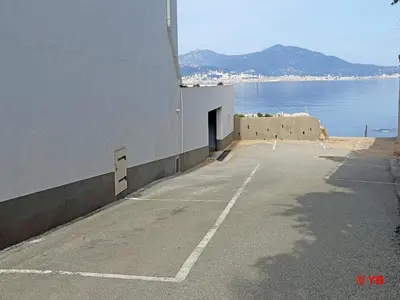 an empty parking lot next to the water at Un balcon sur la mer - Duplex 60 m2 - Chambres à l'étage - Pieds dans l'eau - Accès plage sans route à traverser in Porticcio