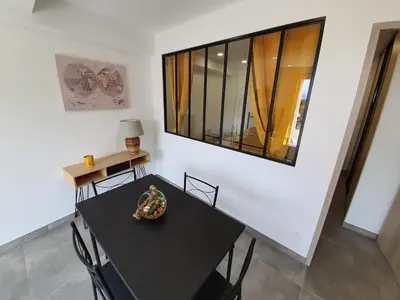 a dining room with a black table and chairs at T2 Propriano vue mer, neuf, climatisé et classé 3 étoiles in Viggianello