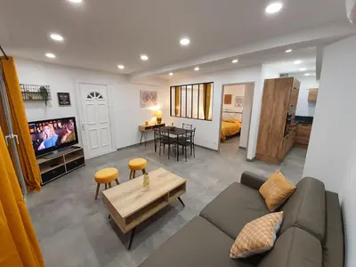 a living room with a couch and a tv and a table at T2 Propriano vue mer, neuf, climatisé et classé 3 étoiles in Viggianello