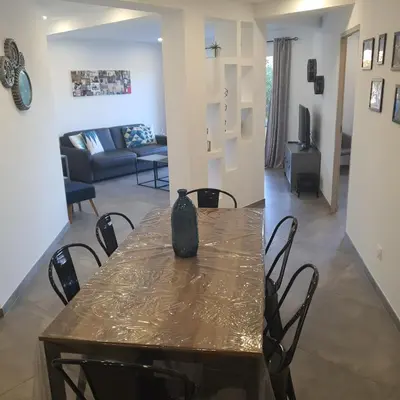 a dining table and chairs in a living room at T3 Propriano vue mer, neuf, climatisé et classé 4 étoiles in Viggianello