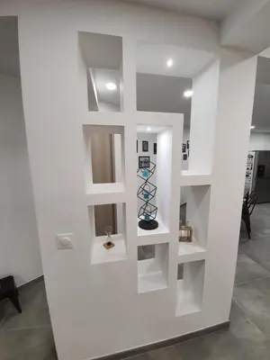 a white wall with shelves in a room at T3 Propriano vue mer, neuf, climatisé et classé 4 étoiles in Viggianello