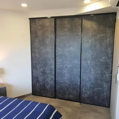 a bedroom with a large metal sliding door at T3 Propriano vue mer, neuf, climatisé et classé 4 étoiles in Viggianello