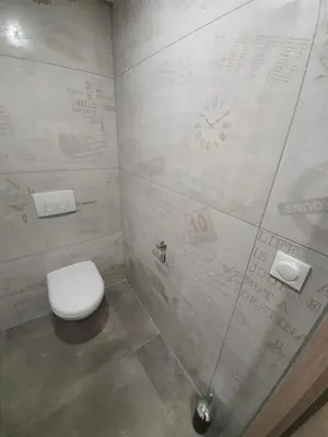 a bathroom with a toilet and a clock on the wall at T3 Propriano vue mer, neuf, climatisé et classé 4 étoiles in Viggianello