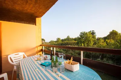 a kitchen with white cabinets and a table and chairs at Studio 2 ou 3 people, 150 m beach, near Ghisonaccia in Ghisonaccia