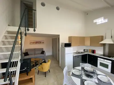a kitchen and living room with a table and chairs at Résidence Mare Bellu Agosta plage in Porticcio