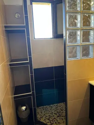a bathroom with a shower with a toilet and a window at Résidence Mare Bellu Agosta plage in Porticcio