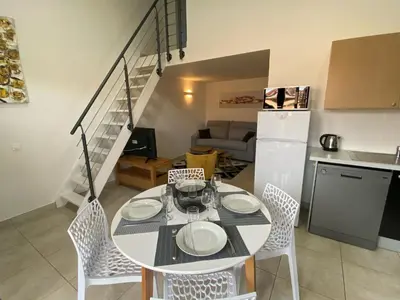 a kitchen and dining room with a table and chairs at Résidence Mare Bellu Agosta plage in Porticcio