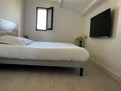 a bedroom with a bed and a television on the wall at Résidence Mare Bellu Agosta plage in Porticcio