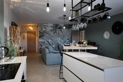 a kitchen and living room with a couch and a table at I Salini - T3 élégant & calme près du centre - Classé 4 étoiles in Porto-Vecchio