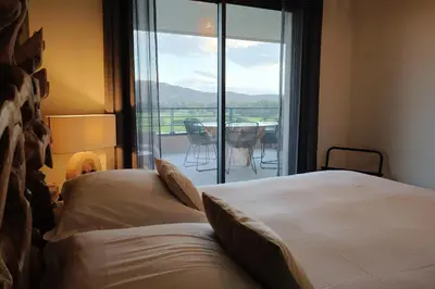 a bedroom with a bed and a view of a balcony at I Salini - T3 élégant & calme près du centre - Classé 4 étoiles in Porto-Vecchio