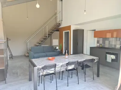 a living room with a table and chairs and a couch at Villas Zanzimare Casa in Grosseto-Prugna