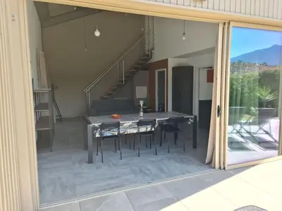 a glass door of a house with a table with chairs at Villas Zanzimare Casa in Grosseto-Prugna