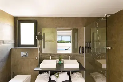 a bathroom with two sinks and a shower at Hôtel Version Maquis Santa Manza in Bonifacio