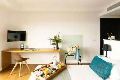 a living room with a table and a desk at Hôtel Version Maquis Santa Manza in Bonifacio