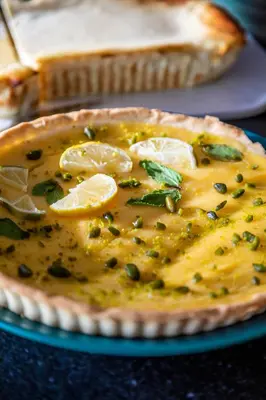 a pie with lemon slices and herbs on a table at Hôtel Version Maquis Santa Manza in Bonifacio