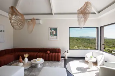 a living room with a couch and a large window at Hôtel Version Maquis Santa Manza in Bonifacio