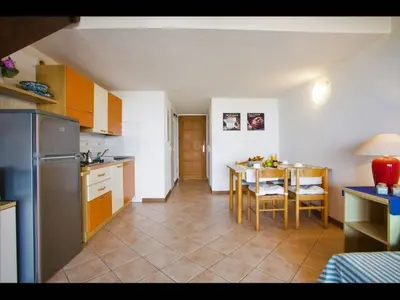 a kitchen with a table and a dining room at Four rooms apartment Ghisonaccia - 150 m from the beach in Ghisonaccia