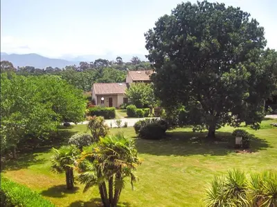 a house in a field with trees and grass at Four rooms apartment Ghisonaccia - 150 m from the beach in Ghisonaccia