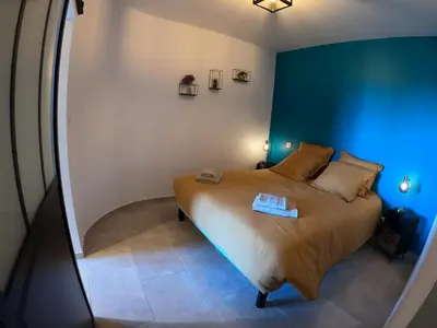 a bedroom with a bed with a blue wall at Le Clos des Milans in Rapale