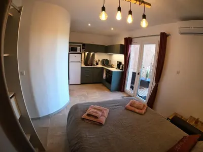 a small bedroom with a bed and a kitchen at Le Clos des Milans in Rapale