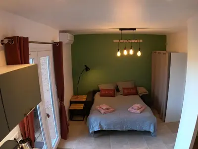 a bedroom with a bed and a green wall at Le Clos des Milans in Rapale