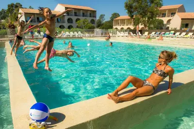 a group of people in a swimming pool at Résidence Goélia Perla D'Isula in Linguizzetta