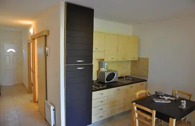 a small kitchen with a table and a microwave at Résidence Goélia Perla D'Isula in Linguizzetta