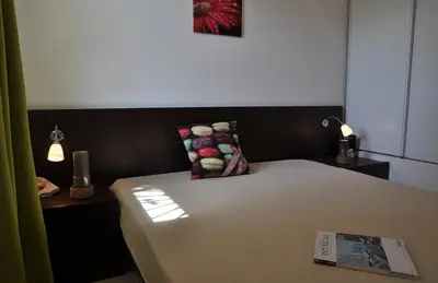 a bed with a pillow and a magazine on it at Résidence Goélia Perla D'Isula in Linguizzetta