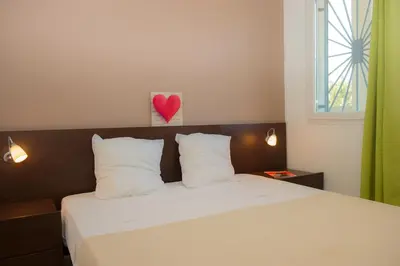 a bedroom with a bed with a heart on the wall at Résidence Goélia Perla D'Isula in Linguizzetta
