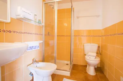 a bathroom with a shower and a toilet and a sink at Air-conditioned apartment near Porto Vecchio, 500 m sea, 8 people, two bathrooms in Zonza