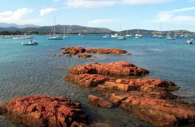 a group of boats in a body of water with rocks at Air-conditioned apartment near Porto Vecchio, 500 m sea, 8 people, two bathrooms in Zonza