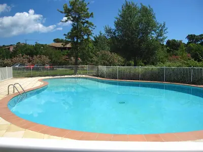 a large blue swimming pool with a fence at Air-conditioned apartment near Porto Vecchio, 500 m sea, 8 people, two bathrooms in Zonza