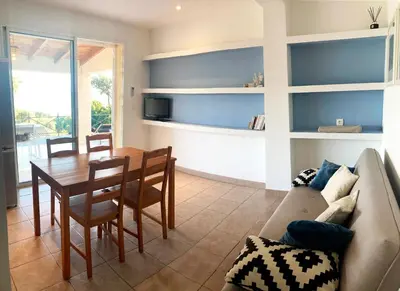 a living room with a table and a couch at Ogliastrello in Olmeto