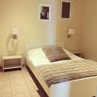 a bedroom with a bed and two lamps and a mirror at Ogliastrello in Olmeto