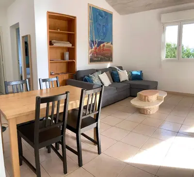 a living room with a table and a couch at Ogliastrello in Olmeto