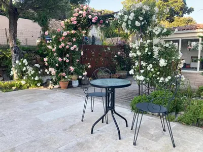 a patio with a table and two chairs and flowers at Ogliastrello in Olmeto