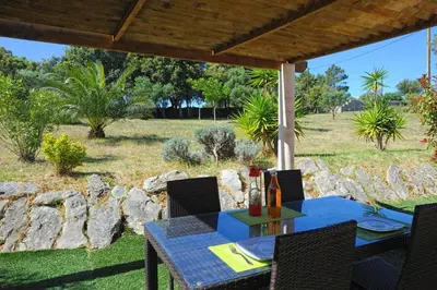 a table and chairs on a patio with a view of a field at Résidence Canava in Bonifacio