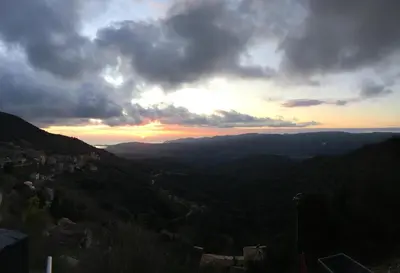 a sunset in the mountains with the sun setting at A Casa Vadiiolina - Chambres d'hôtes d'exception in Sollacaro