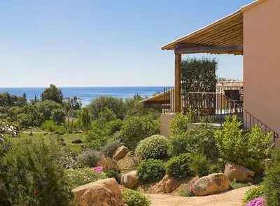 a garden with rocks and plants and a building at Résidence A Rundinella in Porto-Vecchio
