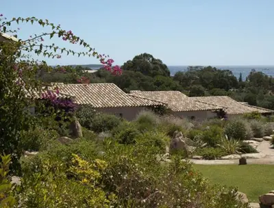a garden with flowers and houses in the background at Résidence A Rundinella in Porto-Vecchio