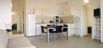 a kitchen with a table and chairs in a room at Résidence A Rundinella in Porto-Vecchio
