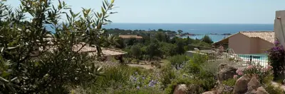 a view of a garden with flowers and a house at Résidence A Rundinella in Porto-Vecchio