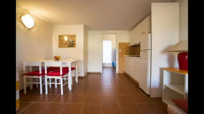 a kitchen and dining room with a table and chairs at Studio 2 people - 150 m from de sea - Ghisonaccia in Ghisonaccia
