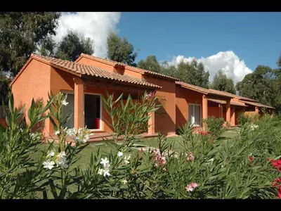 a garden with trees and bushes in front of a building at Marina Corsa Res 4 rooms apartment 2 bathrooms 150 m from the sea Ghisonaccia in Ghisonaccia
