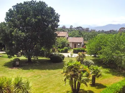 a garden with trees and bushes next to a building at Marina Corsa Residence 3rooms apartment 150 m from the beach - Ghisonaccia in Ghisonaccia