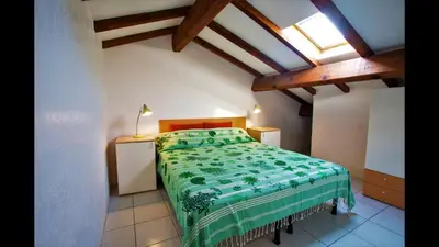 a bedroom with a bed with a green comforter at Marina Corsa Residence 3rooms apartment 150 m from the beach - Ghisonaccia in Ghisonaccia