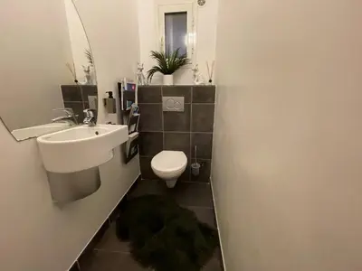 a bathroom with a sink and a toilet and a mirror at Villa CASA BAGGIA, proche plage, piscine à débordement chauffée, pool house in Porto-Vecchio